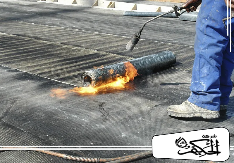 عازل مائي للاسطح في عجمان 0547842313 شركة الحكيم استخدام اللهب لتثبيت لفافة عوازل الاسطح في عجمان، مما يضمن تثبيتها بشكل آمن وفعّال.