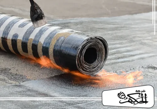 عزل حراري للأسطح بالفجيرة لقطة مقربة تظهر لفافة عازلة ذات خطوط بيضاء وسوداء تتعرض للتسخين المباشر باستخدام شعلة الغاز