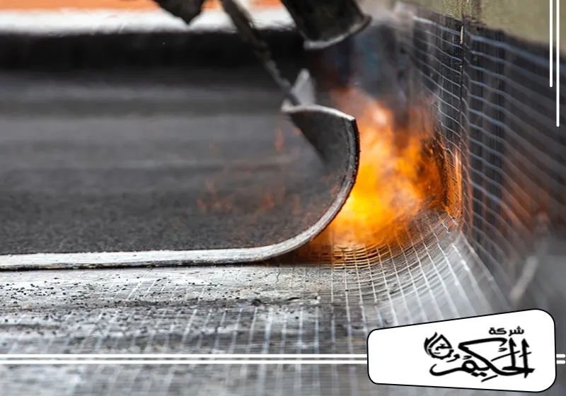 شركة عزل الاسطح من الماء في ام القيوين 0547842313 شركة الحكيم فني شركة عزل حراري في ام القيوين يقوم باشعال اللهب لإغلاق حواف مادة العزل أثناء عملية عزل السقف.