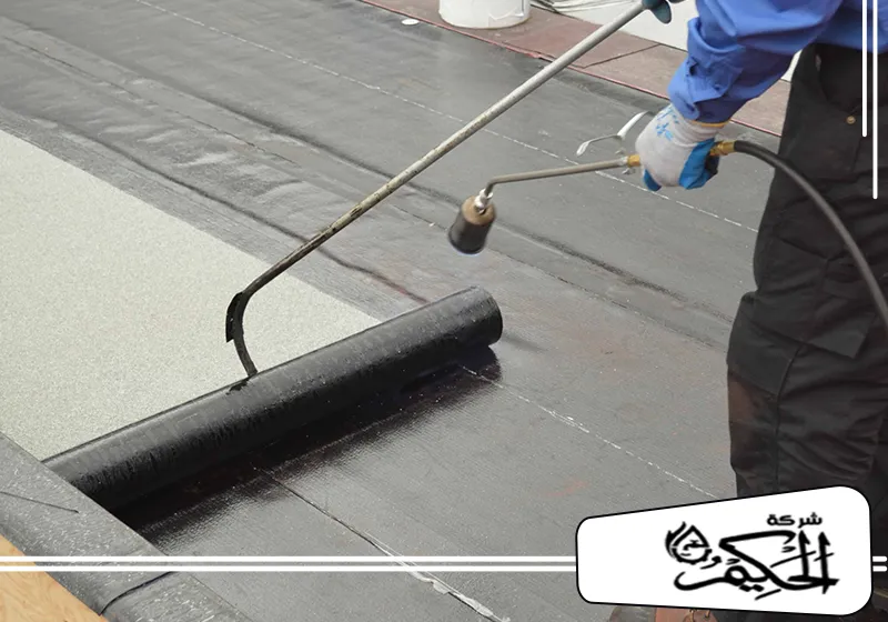 شركة عزل حراري في ام القيوين 0547842313 شركة الحكيم عامل يضيف اللمسات الأخيرة على عزل عزل اسطح في ام القيوين باستخدام مسدس حرارة لربط المواد.