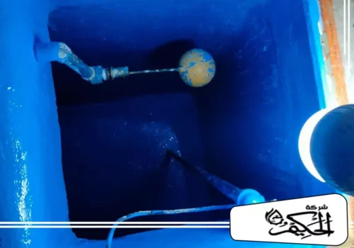 شركة كشف تسربات المياه بدبي عزل خزانات 0547842313 شركة الحكيم جزءًا داخليًا لخزان مياه معزول باللون الأزرق الزاهي، حيث يتم التركيز على ميكانيكية عوامة المياه.